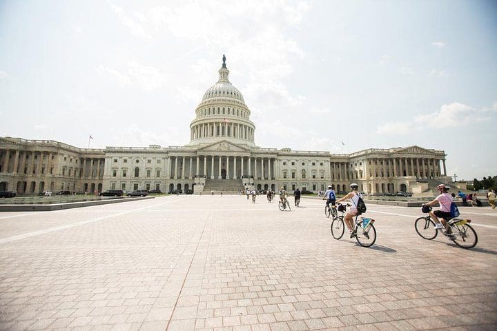 A family bikes in front of the US Capitol building while on the Washington DC Capital Sites Bike Tour.