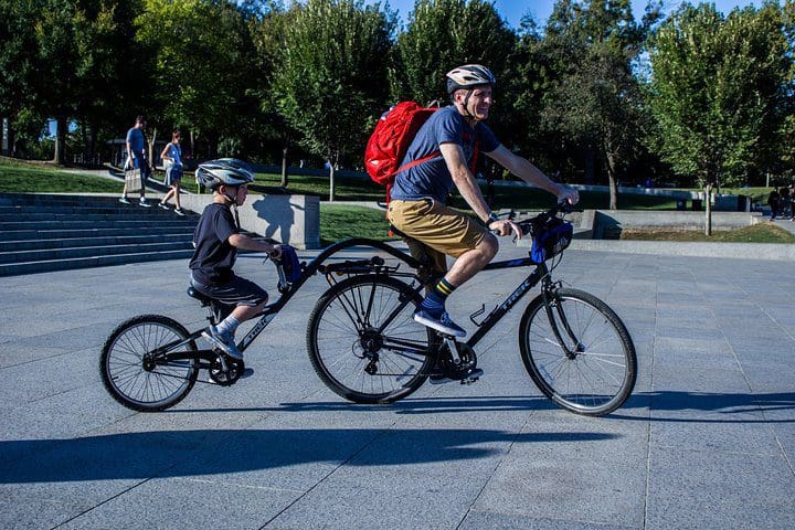 A dad and his young son bike along a path on the Washington DC Monuments Bike Tour.