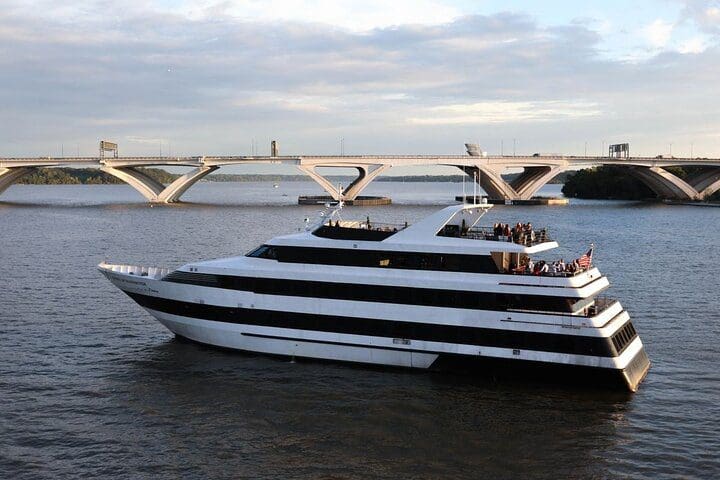A boat moves along the water, carrying the Washington DC Signature Scenic Lunch Cruise.