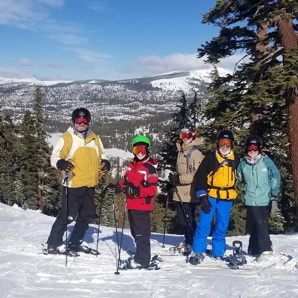 A family of five stands together on a ski trail in Kirkwood.