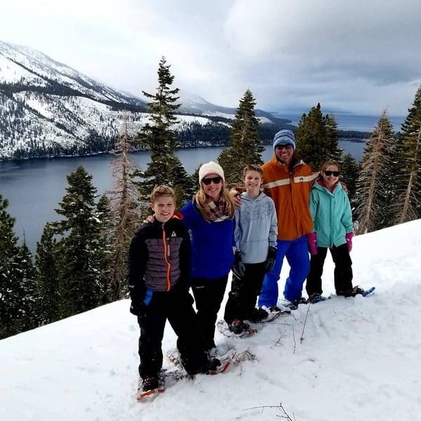 A family of five stands together on snow shoes, one of the best things to do while on a ski vacation to Lake Tahoe with kids.