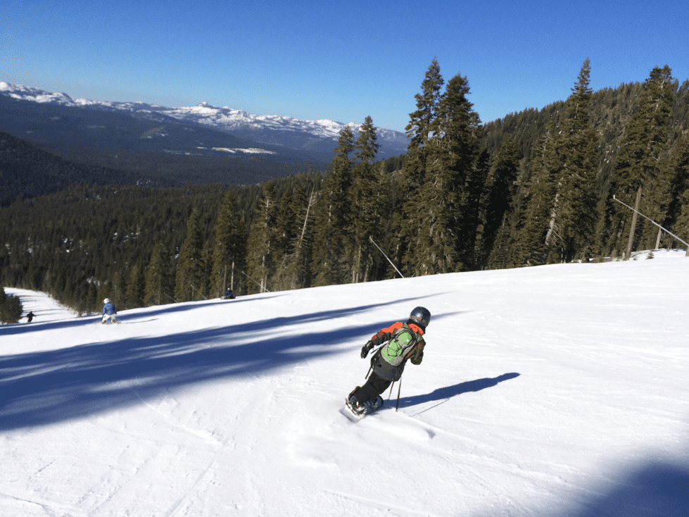 A young boy snowboards down a run at NorthStar Resort.