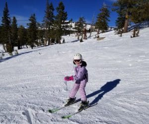 A young girl skis down a slope in Lake Tahoe.