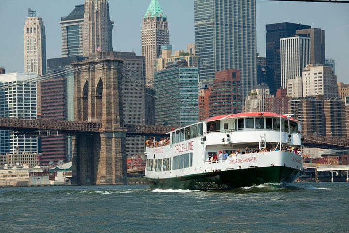 A boat moves down the river taking passengers on the Circle Line: Complete Manhattan Island Cruise.