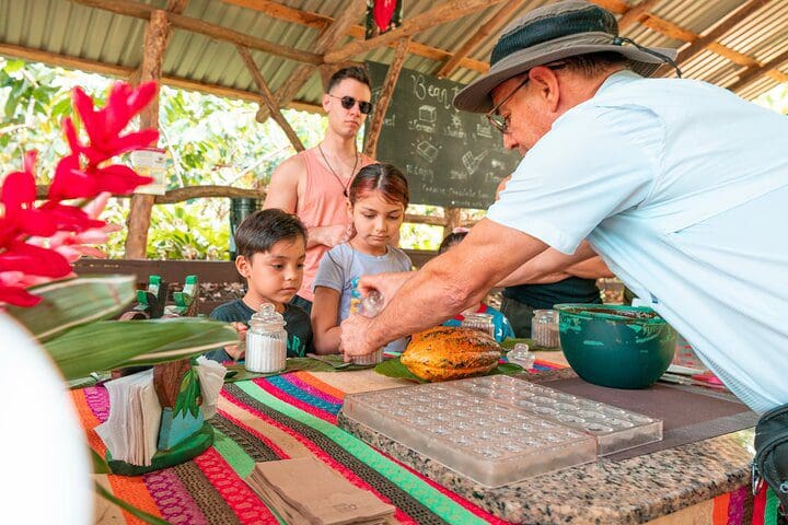 A man teaches a family about chocolate on the Eden Chocolate Tour - The Best Chocolate Tour in La Fortuna.