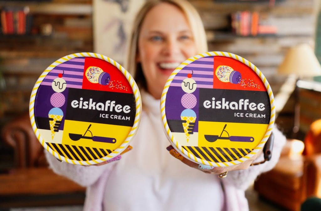 A woman holds out two pints of ice cream at Eiskaffee.