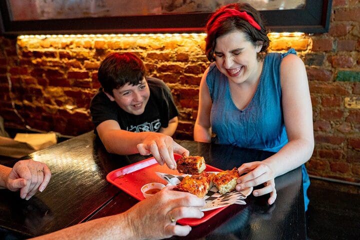 A mom and her young son dig into a pizza on a New York Walking Food Tour With Secret Food Tours.