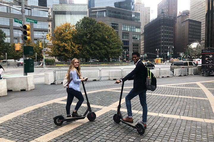 Two teens ride electric scooters on the NYC Central Park Electric Scooter Tour.