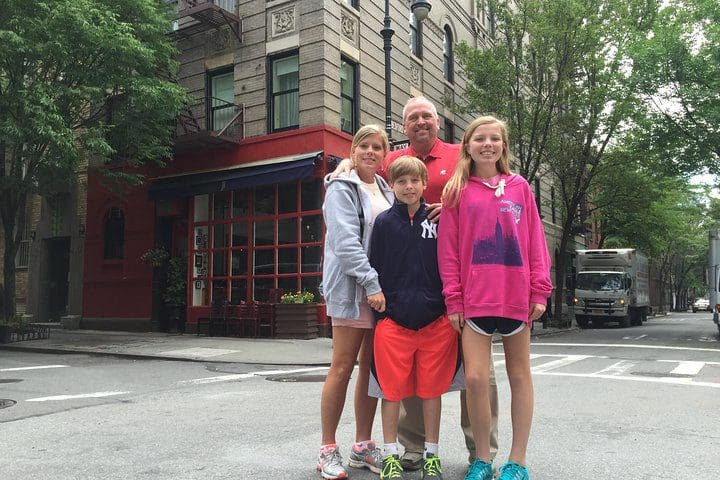A family stands on the corner of a famous TV street in NYC on the NYC TV & Movie Tour.