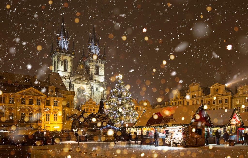 Old Town Prague, one of the best places for Christmas for families in the world, lit up with Christmas lights, with a decorated tree in the center.