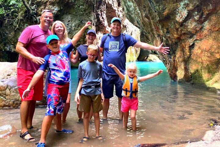 A family poses together, while enjoying the Private La Leona Waterfall Adventure Hike (Self-Drive) tour.