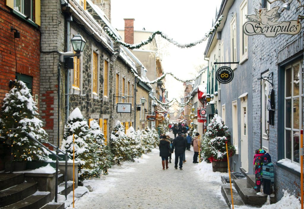 A snowy street in Quebec City, decorated with Christmas lights.