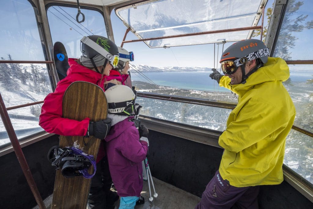 Two parents and their young child ride the aerial tram at Heavenly Resort.