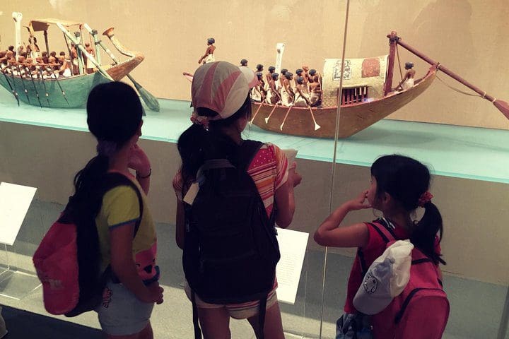 Three kids look at a museum exhibit on the Skip the Line Kids and Families New York Metropolitan Museum Private Tour.