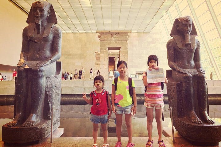 Three kids stand amongst Egyptian statues on the Skip the Line Kids and Families New York Metropolitan Museum Private Tour.