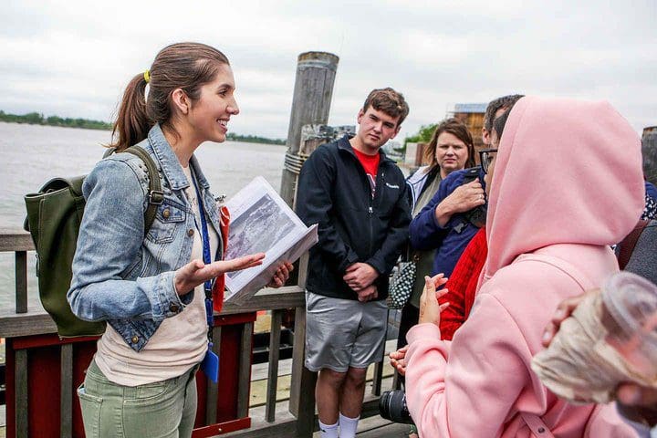A tour guide provides information on a Statue of Liberty & Ellis Island Tour: All Options with Tripadvisor.