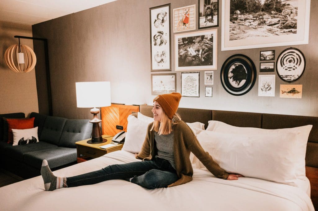 A woman relaxes on a bed, while staying at Renaissance Minneapolis Bloomington Hotel.