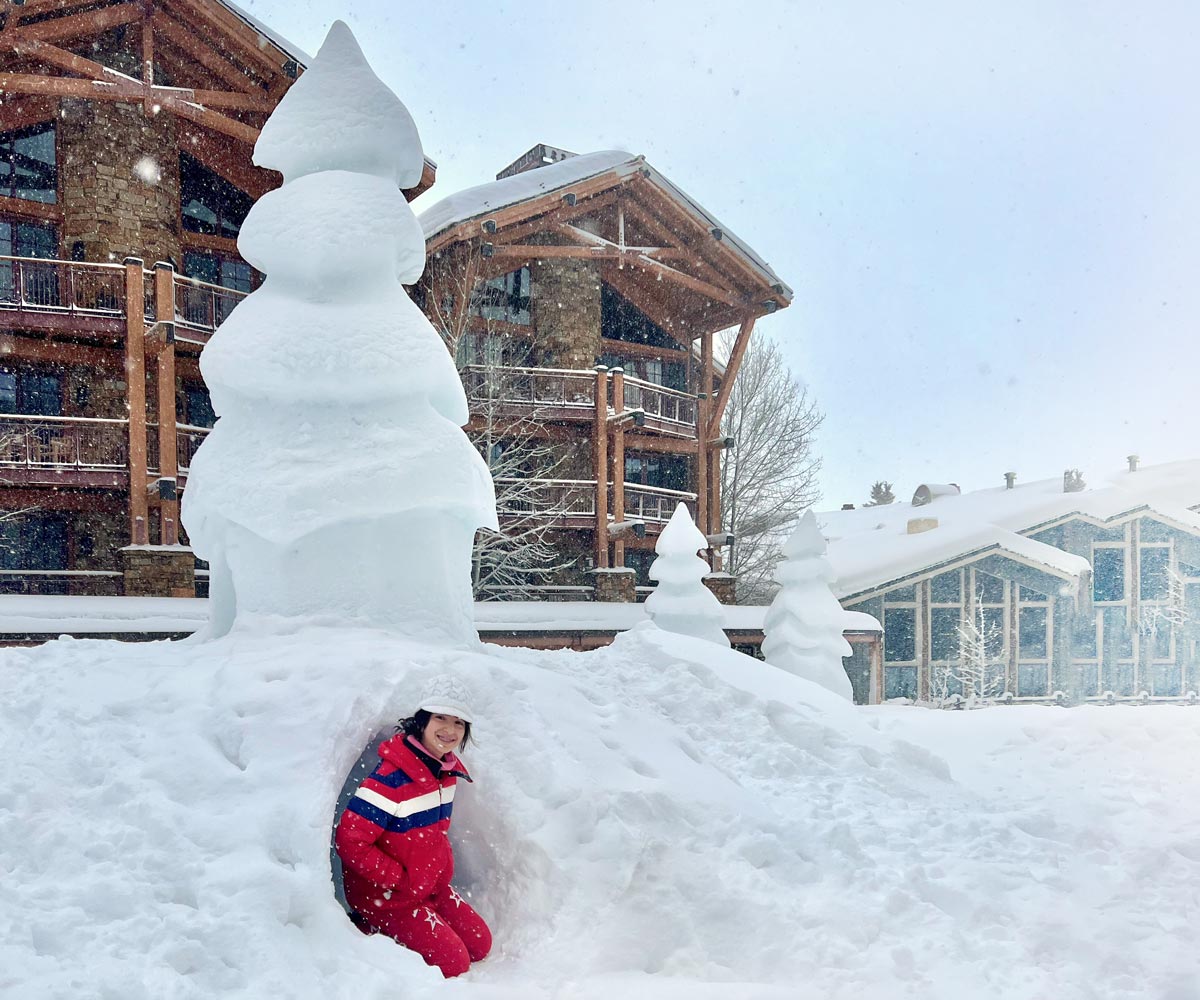 A young boy building a snowman in Jackson Hole, Wyoming