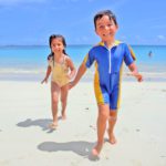 Two kids running on the beach in the Dominican Republic, one of the best affordable Caribbean islands for families