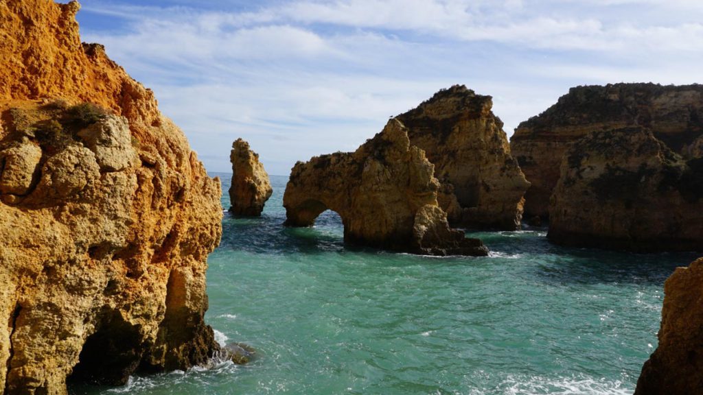 A view of the rock formations on a beach in Lagos, one of the best places to visit in Portugal with kids. 