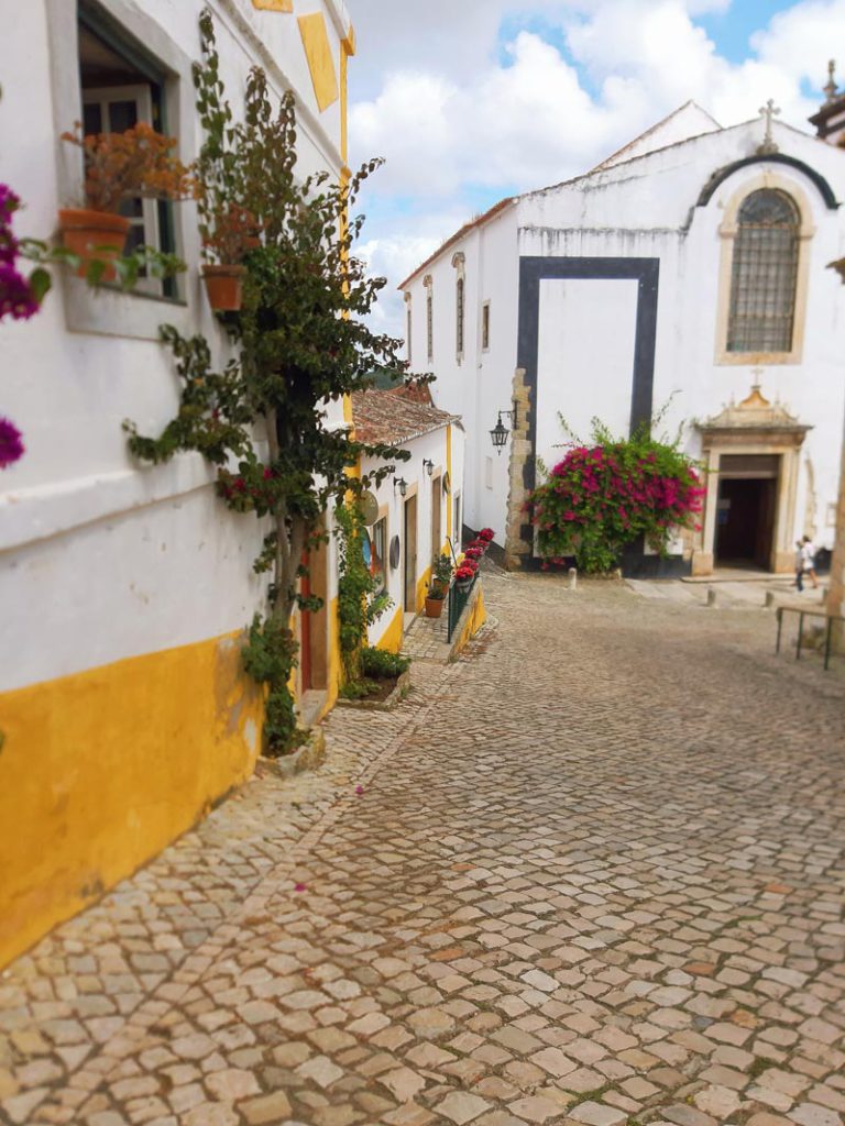 A view of a cute cobblestone street in Obidos, Portugal. 
