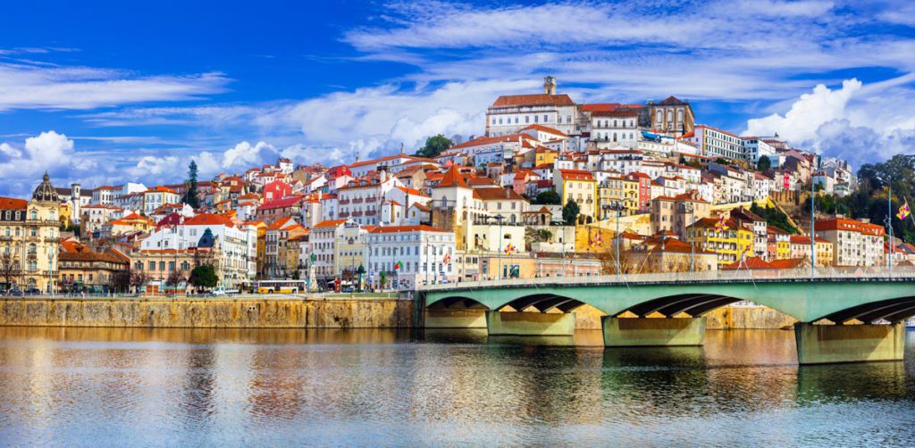 A view of the colorful houses and bridges in Coimbra, one of the best places to visit in Portugal with kids!
