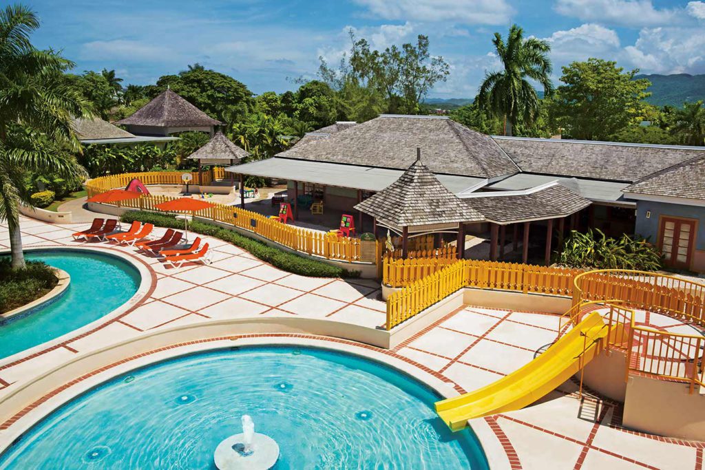 A pool and water slide at Sunset Beach Resort and Spa, one of the best hotels in the Caribbean with a water park for families.