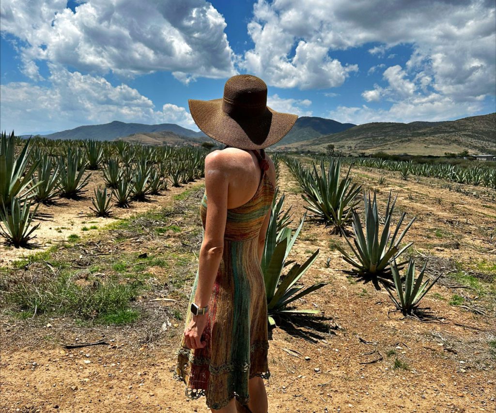 A woman wearing a sun hat overlooking a field near Oaxaca, Mexico.