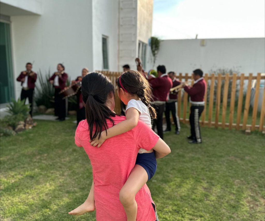 A mother and her child enjoying a send-off by a Mariachi band on their Oaxaca itinerary for families