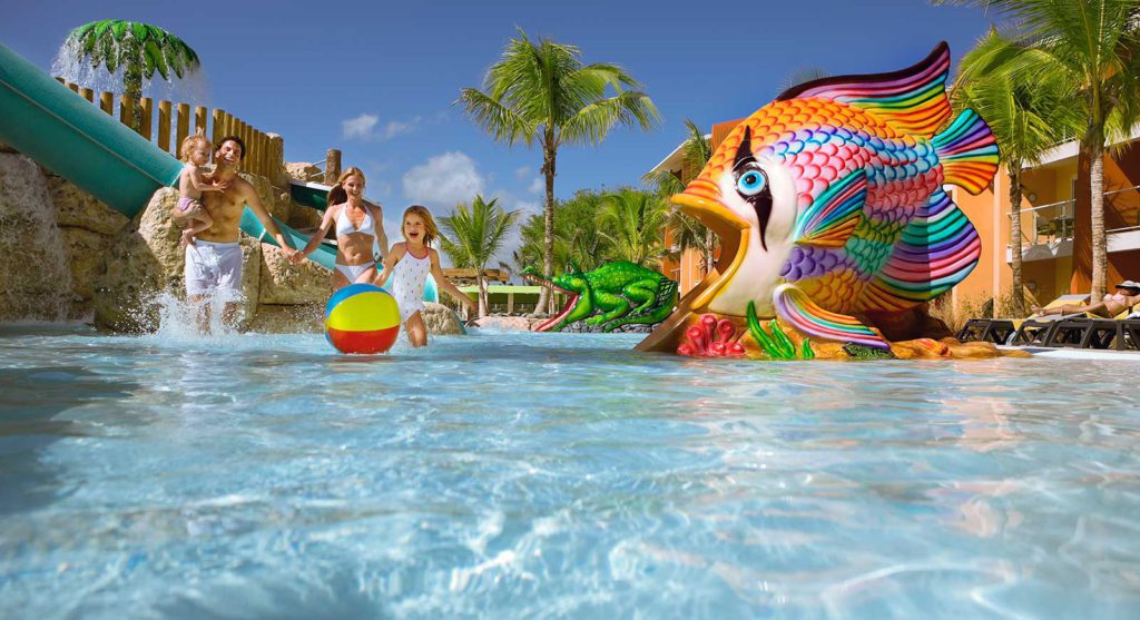 A family playing in the water at Barcelo Bavaro Water Park, one of the best hotels in the Caribbean with a water park for families.