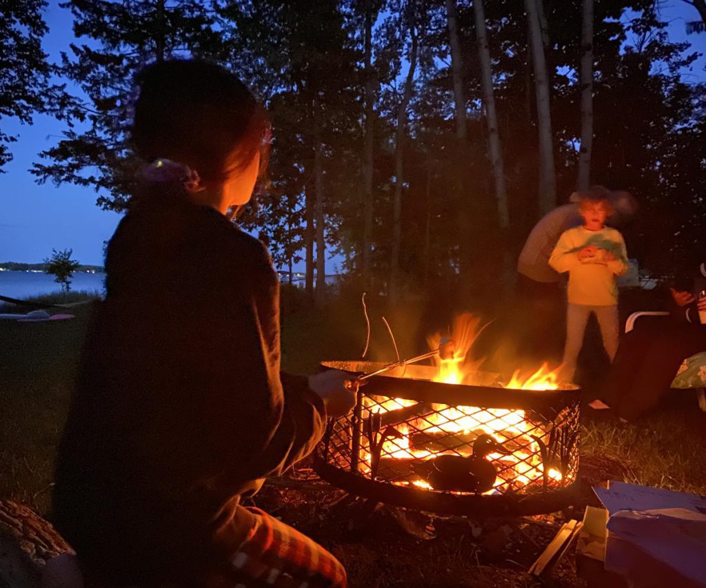 A family gathered around a campfire after a fishing trip in the Midwest.
