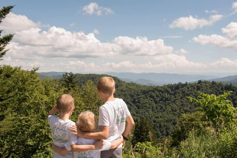 Three kids overlooking the landscape on a hike in Great Smoky Mountains National Park. 