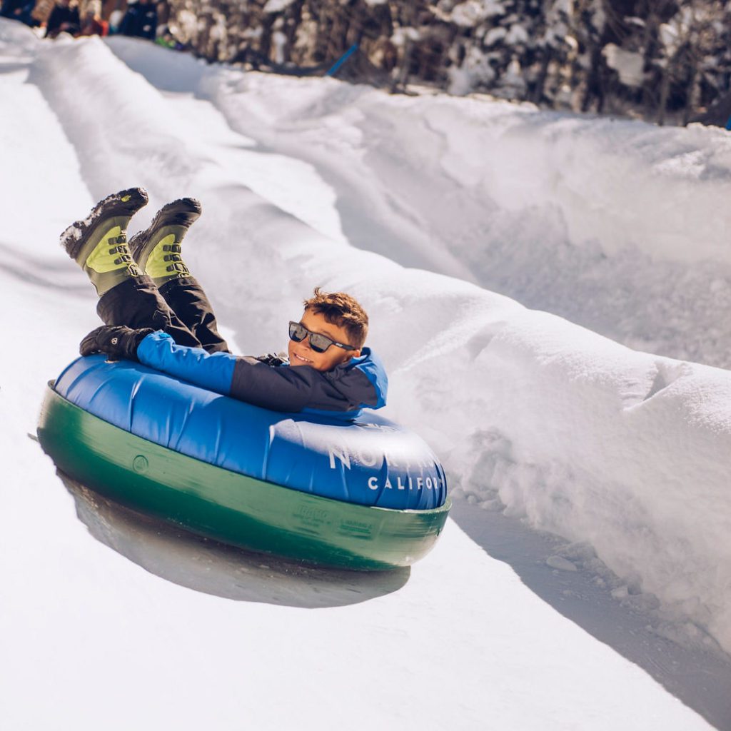 A child snow tubing at Northstar California resort, one of the best places to go snow tubing in Lake Tahoe with kids.