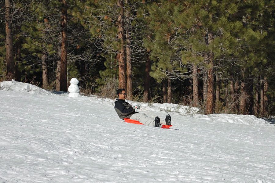 A guy on a sled at Spooner Summit, one of the best places to go snow tubing in Lake Tahoe with kids. 