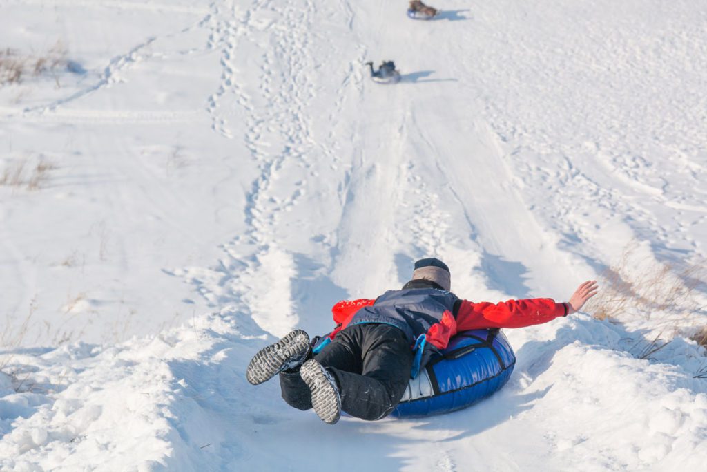 A child snow tubing in the snow. 