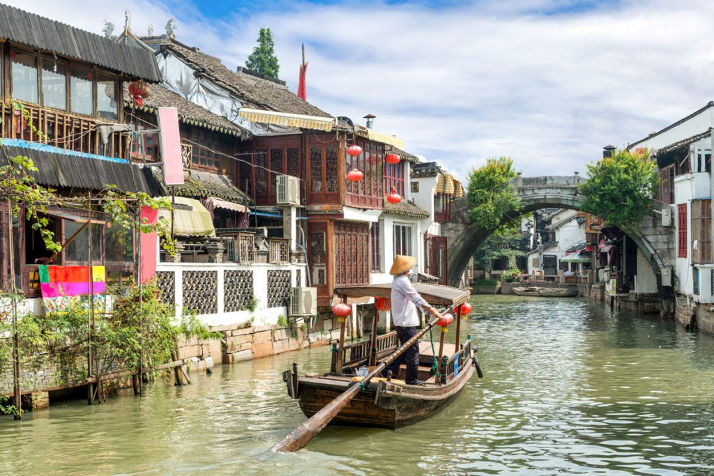 A boat going through the canal in Zhujiajiao, one of the best places to visit in China with kids.