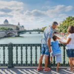 A dad and his two children overlooking the Seine in Paris.